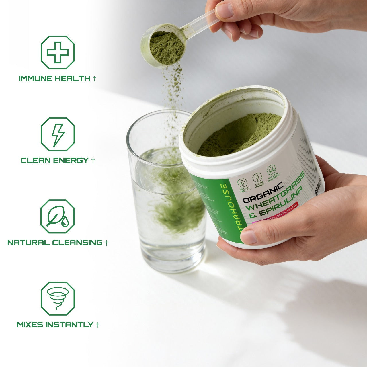 Person pouring NUTRAHOUSE greens powder from a container into a glass with health benefits listed.
